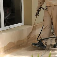 General pest control technician spraying exterior perimeter around a home in Spokane, WA