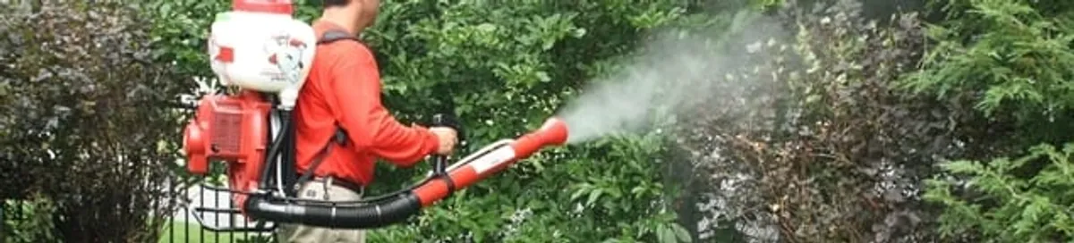 Mosquito control technician fogging shrubs and landscaping for mosquito treatment in Spokane, WA